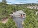 Aerial view of a home nestled among lush green trees with a long driveway at 2122 Montane Dr, Golden, CO 80401