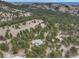 Expansive aerial view of a home surrounded by lush greenery and mountainous terrain at 2122 Montane Dr, Golden, CO 80401