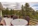 Wide-angle view of a deck with outdoor seating and a beautiful wooded landscape at 2122 Montane Dr, Golden, CO 80401