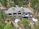 Aerial view of a house with a spacious deck, hot tub, large windows and a tiled roof at 2122 Montane Dr, Golden, CO 80401