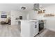 Bright, open kitchen area featuring stainless steel appliances, an island, and hardwood floors at 955 Eudora St # 1606, Denver, CO 80220