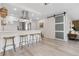 Stylish kitchen with stainless steel appliances, breakfast bar, and sleek sliding barn door to living area at 955 Eudora St # 1606, Denver, CO 80220