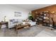 Cozy living room with a comfortable sofa, rustic coffee table, brick accent wall, and shelving at 955 Eudora St # 1606, Denver, CO 80220