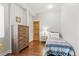 Cozy bedroom with hardwood floors, a decorative dresser, and a comfortable-looking bed at 1686 S Logan St, Denver, CO 80210