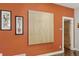 Hallway with bold orange walls, modern art pieces, white trim and baseboards, with wood door at 1686 S Logan St, Denver, CO 80210