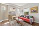 Cozy living room with bright red sofa, colorful accents, fireplace, and a sun-lit window at 1686 S Logan St, Denver, CO 80210