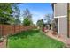 Spacious backyard with a well-maintained lawn, mature trees, and a cozy gazebo at 11076 Cotton Creek Dr, Westminster, CO 80031