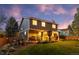 Expansive backyard with lush green lawn, patio with a gazebo, barbecue grill and exterior of the home at dusk at 11076 Cotton Creek Dr, Westminster, CO 80031