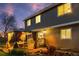 Exterior view of a home featuring a cozy, curtained backyard patio with string lights and manicured landscaping at 11076 Cotton Creek Dr, Westminster, CO 80031