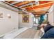 Finished basement showcasing exposed ceiling beams, cozy sitting area and functional space at 11076 Cotton Creek Dr, Westminster, CO 80031