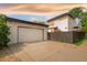 Home featuring a large garage, exterior lighting, modern architecture, and privacy fence at 2990 Osceola St, Denver, CO 80212