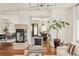 Open-concept living room with stone fireplace and hardwood floors flowing into a dining area at 2990 Osceola St, Denver, CO 80212