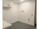 A laundry room featuring gray epoxy floors and white cabinets for storage at 10751 W 66Th Ave, Arvada, CO 80004