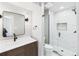 Modern bathroom showcasing a glass shower, floating vanity, black fixtures, and a sleek, rectangular mirror at 3957 S Peach Way, Denver, CO 80237