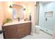 Modern bathroom featuring quartz counters, a wooden vanity, sleek fixtures, and a glass-enclosed shower at 3957 S Peach Way, Denver, CO 80237
