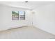 Bright, empty bedroom featuring two windows, neutral carpet, and white walls with a door to the left at 3957 S Peach Way, Denver, CO 80237