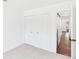 Bright bedroom featuring a closet, neutral carpet, and white walls for a clean and airy aesthetic at 3957 S Peach Way, Denver, CO 80237