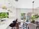 Open-concept dining area with modern lighting, breakfast bar and views of the backyard at 3957 S Peach Way, Denver, CO 80237
