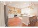 Well-lit kitchen featuring custom cabinets, stainless appliances, and a breakfast bar at 3957 S Peach Way, Denver, CO 80237