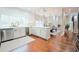 Open kitchen with white cabinets, stainless appliances, and adjacent dining area at 3957 S Peach Way, Denver, CO 80237