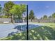 Well-maintained tennis court with new netting, surrounded by trees and a fence for privacy at 3957 S Peach Way, Denver, CO 80237