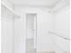 Walk-in closet with white shelving and neutral carpet featuring an open door to another room at 3957 S Peach Way, Denver, CO 80237