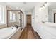 Primary bathroom features a double sink vanity, glass enclosed shower, soaking tub and hard surface floors at 24748 E 40Th Ave, Aurora, CO 80019