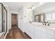 Bright bathroom with dual sinks, sleek fixtures, and a view of the glass-enclosed shower and walk-in closet at 24748 E 40Th Ave, Aurora, CO 80019