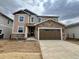 Two-story home with a two-car garage, stone accents, neutral siding and a concrete driveway at 24748 E 40Th Ave, Aurora, CO 80019