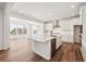 Gourmet kitchen featuring white cabinets, a large island, stainless steel appliances, and open dining space at 24748 E 40Th Ave, Aurora, CO 80019