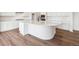 Spacious kitchen showcasing a curved island with a sink and ample counter space, complemented by wood floors at 24748 E 40Th Ave, Aurora, CO 80019