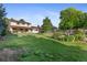 Expansive backyard with well-maintained lawn, covered patio, and mature trees, perfect for outdoor activities at 874 Mercury Cir, Lone Tree, CO 80124