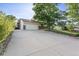 View of a long driveway leading to a two-car garage and manicured front lawn at 874 Mercury Cir, Lone Tree, CO 80124