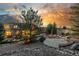 Backyard with illuminated stone patio and water feature. Mature evergreens and landscaping create a relaxing outdoor space at 20148 E Windy Pine Pl, Parker, CO 80134