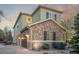 Exterior view showing the two-car garage and detailed stone on this home's facade at 20148 E Windy Pine Pl, Parker, CO 80134