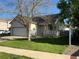 Charming single Gathering home with mature trees, green lawn, white trim, and a two car garage at 5010 Golden Eagle Pkwy, Brighton, CO 80601