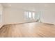 Open living room with wood floors and ample natural light from large windows at 7260 Waterleaf Trl, Littleton, CO 80125
