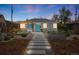 Charming gray brick home featuring a walkway to a bright blue front door and artistic modern landscaping at 822 Poplar St, Denver, CO 80220