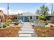 Charming gray bungalow featuring a modern walkway, beautiful landscaping, and a bright blue front door at 822 Poplar St, Denver, CO 80220