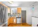 A well-lit kitchen featuring stainless steel appliances, wooden cabinets, and wood flooring at 822 Poplar St, Denver, CO 80220