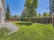 Expansive backyard with manicured lawn, mature trees, and a charming privacy fence for outdoor enjoyment at 1290 W Quincy Cir, Englewood, CO 80110