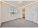Cozy bedroom featuring soft gray carpet, natural light from the window, and a walk-in closet at 1290 W Quincy Cir, Englewood, CO 80110