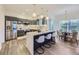 Modern kitchen with stainless steel appliances, quartz countertops, and open layout to dining area at 1290 W Quincy Cir, Englewood, CO 80110