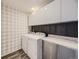 Well-lit laundry room with updated cabinets, countertops, and a modern washer and dryer at 1290 W Quincy Cir, Englewood, CO 80110