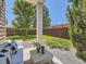 Inviting covered patio with comfortable seating, decorative vases, and views of the landscaped yard at 1290 W Quincy Cir, Englewood, CO 80110