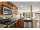 Modern kitchen featuring stainless steel appliances, granite counters, and wooden cabinets at 100 Park W Ave # 301, Denver, CO 80205