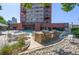 A pool area with a BBQ kitchen, rock garden, and a glimpse of the building behind it at 100 Park W Ave # 301, Denver, CO 80205
