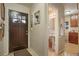 Welcoming entryway featuring a stylish front door, adjacent half bath, and hardwood floors at 3311 S Dahlia St, Denver, CO 80222