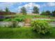 Beautiful backyard with tiered garden beds, lush greenery, and a charming wooden fence at 5774 S Genoa Ct, Aurora, CO 80015