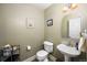 Cozy half bathroom with a pedestal sink, decorative mirror, and neutral wall colors at 5774 S Genoa Ct, Aurora, CO 80015